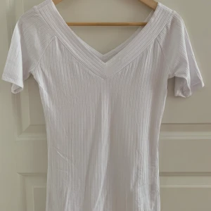 Off shoulder topp - Toppen har en off shoulder- design, ett stretchigt, ribbat material och en tättsittande passform. Färgen naturvitt, kommer från Asia, storlek 36. Använd få gånger. 