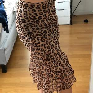 Säljer en fin lite flowig kjol med leopardmönster från Nelly!🤎 den har volanger längst ner men är tight runt låren och sitter jättefint! Knappt använd. Resår i midjan, den åker inte ner. 