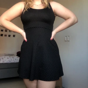 Prickig klänning i stl XS - Svart klänning med vita små prickar från H&M i stl XS. Stretchigt tyg. Banden på klänningen korsas i ryggen, kan skicka fler bilder om det önskas. Använd 1 gång så den är i bra skick. 