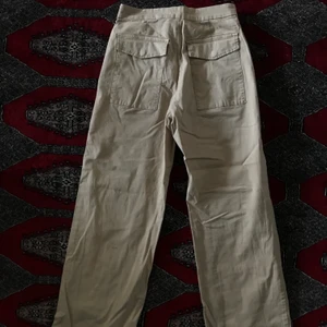 Högmidjade vida beiga byxor - Ett par beiga byxor med vida ben och högmidjade! Använda fåtal gånger. Uppsydda i benen men går lätt att sprätta upp och få längre om man är 170+! Skriv för fler bilder/mått! Allt så bort på min sida pga flytt! Priser går att diskutera! :)