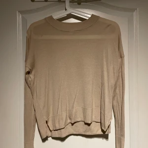 Beige tunn tröja H&M - Beige stickad tunn tröja från H&M. Finns ett hål på högra axeln (se bild 2). Köparen står själv för frakten.