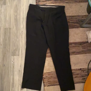 Kostymbyxor - Svarta kostymbyxor i okänd storlek men passar som 40-44. Köpta second hand men oanvända och i bra skick :)