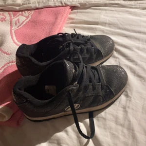  Svarta Heelys - Ett par svarta heelys som är i storleken 38 