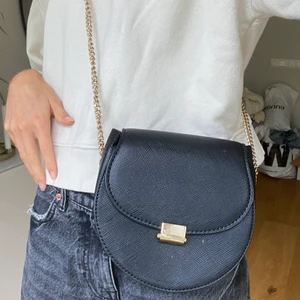 Väska - Jag säljer denna fina svarta väska med guldiga detaljer från mango då jag har för många. Den är i fint skick och det går att sjustera längden på kedjan. Säljs för 110kr+frakt som köparen står för🖤hör av dig vid frågor eller intresse