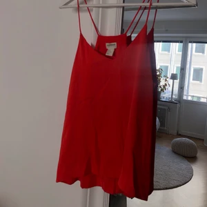 Oranget linne strl. 36 - Somrigt röd/oranget linne i strl. 36 från H&M conscious collection. Materialet är lite silkesaktigt så linnet sitter väldigt fint på! Är lös passform. Fraktkostnaden ingår ej i priset.