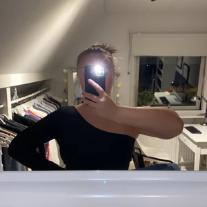 Svart topp från Gina Tricot  - Svart ribbad topp med en lång ärm och en off shoulder