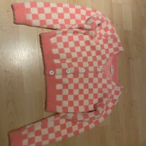 Rosa/vita rutor tröja  - Det är en jätte mysig och rosa tröja som är fluffig och den är  använd ett par gånger,den är i storlek 152 men kan användas som en lite kortare tröja.
