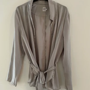 Blazer - Champagnefärgad luftig blazer. Superskönt material. Knyte i midjan. Använd 1 gång. 