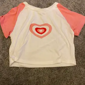 Gullig t-shirt/topp med ett hjärta i mitten. Bra skick och utan några defekter.