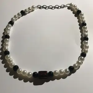 Pärlhalsband svarta & vita pärlor med en svart & brun pärla i mitten, går att gör längre och kortare 