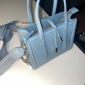 Väska från zara.  - En oanvänd väska från zara i ljusblå. Den har även ett band så du kan välja om hur du vill ha den. 