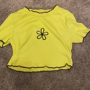Crop top  - Lime grön crop top med en blomma där fram. Tröjan är nästan aldrig använd och är i bra skick. Priset kan diskuteras.