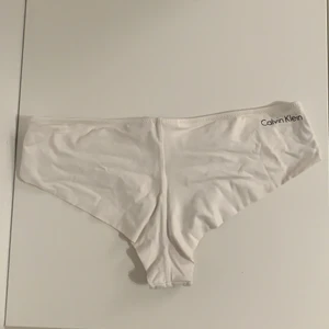Calvin Klein vit bikiniunderdel - Snygg underdel från CK som inte kommer till användning. Istället för en söm bak så är det en vikning som hålls på plats vilket gör att man inte får ”dubbelrumpa”. 