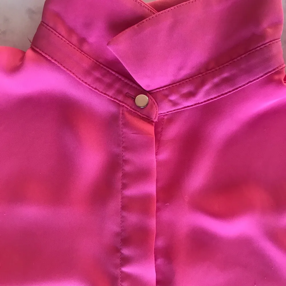 En fin härlig rosa färg på en fin blus, denna blus är från H&M i strl 34. Den sitter jättebra på, materialet är skönt och bekvämt. Denna blus är använd ett par gånger men är ändå på en förvånansvärt bra skick, köpt för snart ett år sen. Hade kombinerat denna blus med vita jeans och lite guld smycken då den har en guld knapp som detalj, väldigt elegant och stillig.Extra knappar följer dessutom med som jag fick vid köpet(Väljer att rensa bort denna blus därför att jag har nu ändrat på min still 💕). Blusar.