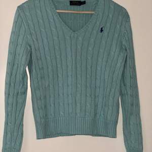 This is a V-neck sweater from Polo Ralph Lauren in turquoise. It is in good/medium condition. The color is still intact. Good to combine with blouses :) 