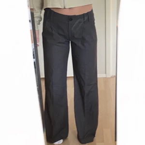 Lågmidjade vida kostymbyxor - Gråa vida lågmidjade kostymbyxor från 90-talet. Väldigt fin passform och väldigt bra längd för folk över 170. 