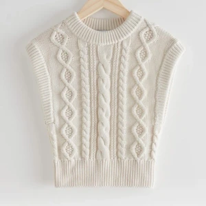 Fitted Cable Knit Vest - DESIGNED IN STOCKHOLM.                                           Short fitted vest with a cable knit structure. Organic cotton                                                                   Använt 1 gång, köpte den för 490kr