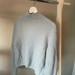 Blå stickad tröja &otherstories - Fin ljusblå stickad tröja från other stories. Ribbad med en polokrage. Fint men använt skick. 100% ull. Perfekt till hösten. 