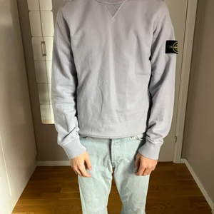 Ljuslila/grå stone island sweatshirt  - Super snygg stone island sweatshirt med väldigt unik färg, mycket bra skick, inköpspris: 1800, stl Small herr men passar även XS herr för den är inte så stor i storleken. Den är äkta, finns clg kod