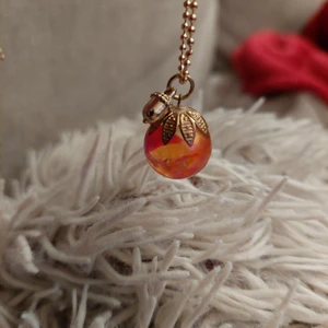 Halsband - Halsband 25 cm långt. Röd glaskula fäst i guldblad.