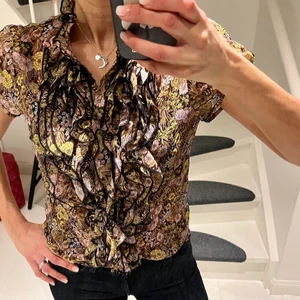 Saint Tropz blus  - Klassiska blusen från Saint Tropez med härligt krås. Sitter så fint på! Underbart mönster, blommigt i rosa, gul och svart! Stlk S. Använd ett fåtal tillfällen!