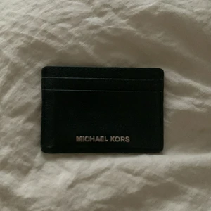 Michael Kors korthållare - Korthållare i fake-läder. Väldigt bra skick, ser oanvänd ut! Haft i snart 1 år men har en ny, därför säljs denna.                                        Nypris: 700kr. Köparen står för frakt (45kr)
