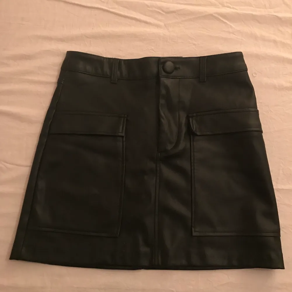Cool svart kjol från Zara i skinn/läderimitation strl XS och i perfekt skick då den aldrig är använd💕. Hameet.