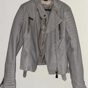 Populära skinnjackan från Chiquelle - Säljer denna jacka pga. för liten storlek. Det är storlek 40 på denna men den passar dig som bär 38, ganska liten i strl. Jätte fin grå neutral färg som passar fint med de silvriga detaljerna! Ord pris. 699