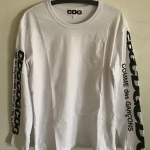CDG / Comme Des Garçons Arm Logo Long Sleeve T-Shirt  Size large, fits like a regular men’s size medium.  Excellent condition, no flaws or damage.  DM if you need exact size measurements.   Buyer pays for all shipping costs. All items sent with tracking number.   No swaps, no trades, no offers. 