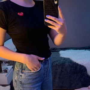 Svart t-shirt  - Svart ribbad t-shirt med ett rött hjärta på ens bröstet