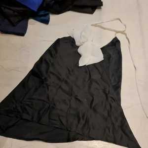 Linne  - Svart linne med vit rosett. Vringad bak i ryggen. 