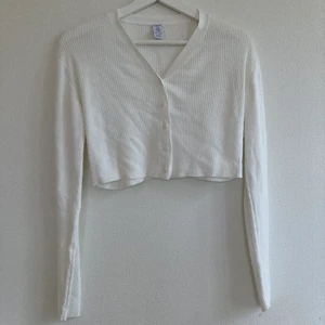 Vit stickad cropad kofta - En fin stickad kofta från Lindex som är cropad. Den är i storlek 134-140 men passar på mig som vanligt vis har XS