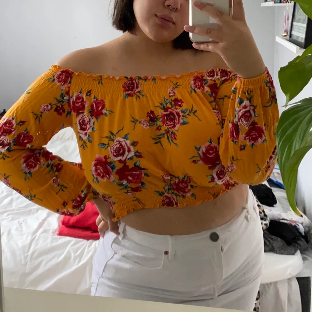 Orange off-shoulder topp från H&M med blommönster. Stretchigt tyg, väldigt bekväm. Storlek M. Jag bär vanligtvis storlek M/L och är 172 cm lång.. Toppar.