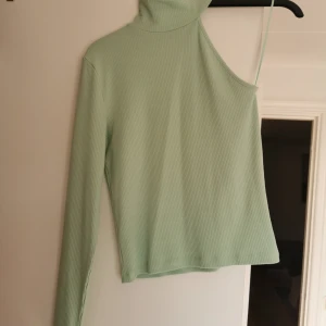 Topp ifrån BikBok - Snygg grön topp ifrån BikBok. Storlek Medium. Passar även en Large skulle jag säga. Väldigt snygg med bara en arm. Väldigt lite använd då jag aldrig kände mig bekväm i den. Tvättad en gång. 