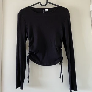 Tröja med snörning - Säljer denna fina tröja med snörning i sidorna. Plagget är använt ett fåtal gånger och är i strl XS men skulle lika gärna passa S då det är stretch i tröjan. Frakten ingår ej