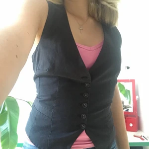 Figursydd väst - En figursydd kostym väst i svart med vita ränder.Där man kan reglera storleken där bak. Översta knappen saknas men bortsett från det i bra skick!