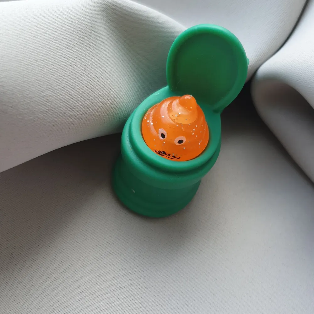 En rolig fidget toy grön snygg orange och lite glittrig man poppar upp självaste bajskorven🙈. Övrigt.