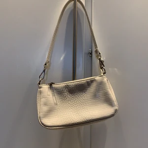 Beige Gina Tricot handväska - Väldig snygg handväska. Hr använt den ganska mycket men är fortfarande i bra form. Lite rostig på kedjan men det syns inte. Nypris: 299kr