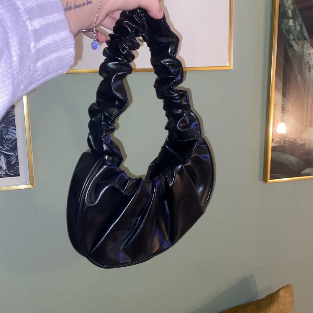 Säljer denna svarta handväska! Den är relativt liten, därför kommer den inte till användning, det vill säga aldrig använd. Passar mer att hålla i handen och kanske inte runt axeln. Köpte på shein för 100kr. Säljer för 50kr men köparen står för frakten. ❤️. Väskor.