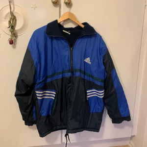 80/90 tals Adidas jacka - 80/90 tals Adidas jacka. Köpt på second hand för ca 300kr. Jag är 169cm och den går ner till knäna på mig. Har lite små hål men dom är knappt synbara. Man kan även använda den ut och in. Insidan är dock lite nopprig men det är ingen jag kunnat ta bort.😊