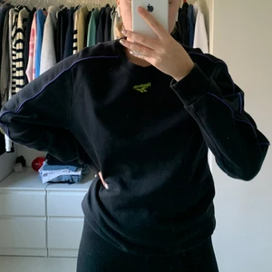 College tröja från Reebok  - Jätte snygg och cool college tröja från Reebok, den den är stor och skön och snygg som vardagströja, knappt använd och i bra skick. Den har ett neongrönt märke vid kragen och lila detaljer längs ärmarna, vilken gör den jätte cool.💯💞👌🏼