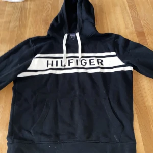 Hoodie Hilfiger - Hoodie i bra skick. Färgen har brustit lite i kanten. Se bild 3. Märks inte på håll dock. Nypris ca 1200 