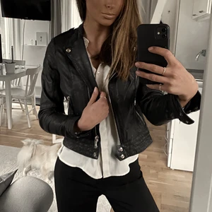 Jofama - Biker by Marie Serneholt  - En svart läderjacka från Jofama i samarbete med Marie Serneholt. Guldiga detaljer. Inköpspris 2899kr, säljs för 1300kr. Riktigt snygg bikerjacka i mycket bra kvalitet och äkta läder. Innefoder: 20% Viscos 80% Polyester 