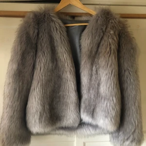 Pälsjacka faux fur  - Grå pälsjacka i faux fur. Använd 1 gång. Väldigt fin kvalite. Passar xs-m beroende på hur man vill att den sitter. 