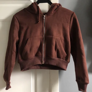 Brun hoodie - Säljer denna bruna hoodie med dragkedja från shein. Hoodien är croppad och säljer då armarna var lite för korta. Jättefin kvalitet då den aldrig är använd.