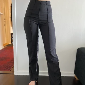 Kostymbyxor med detalj - Kostymbyxor från prettylittlething i storlek 8. Jättefin passform och perfekt i längden om du vill ha lite längre byxor. Dock lite för tighta kring låren därav anledningen till att jag säljer dem. Prislapp finns kvar. köpare står för frakt