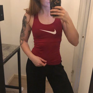 Nike träningslinne - Säljer detta vinröda träningslinne från Nike i storlek XS 🤩