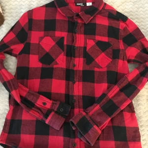 Rutig Skjorta - Röd och svart rutig skjorta! Så snygg men kommer inte till användning längre, så någon annan kanske vill köpa den! Den har knappar hela vägen och två fickor på framsidan! Den är i barnstorlek men jag skulle säga att den är en xs/s ungefär! Det är bara att komma privat vid frågor eller om du vill ha fler bilder!🥰