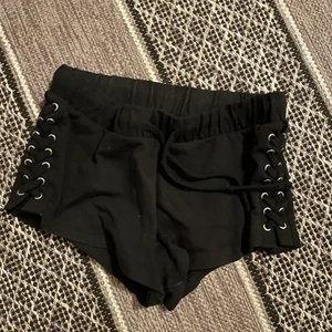 Svarta kortbyxor från FB sisters  - Ett par svarta kortbyxor från FB sisters med fina metall detaljer på vardera sida. 