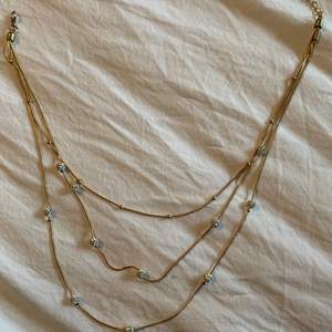 Ett guldigt halsband med silver pärlor på!